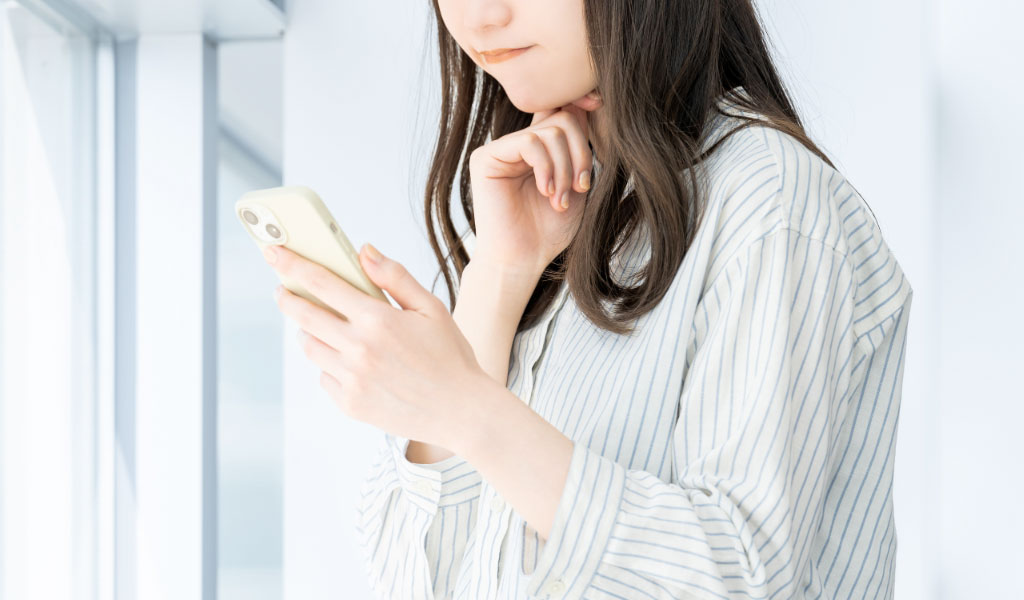 SNSをチェックする女性のイメージ画像