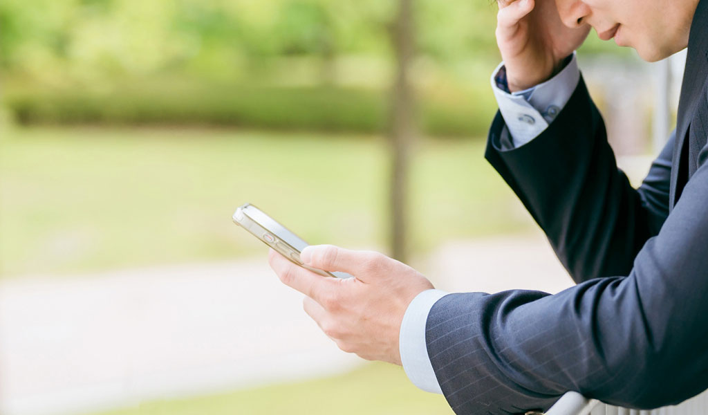 自分の携帯電話に電話をかける男性