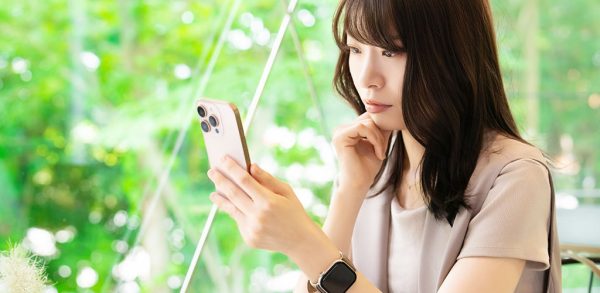 スマホの画面を凝視する女性のイメージ画像